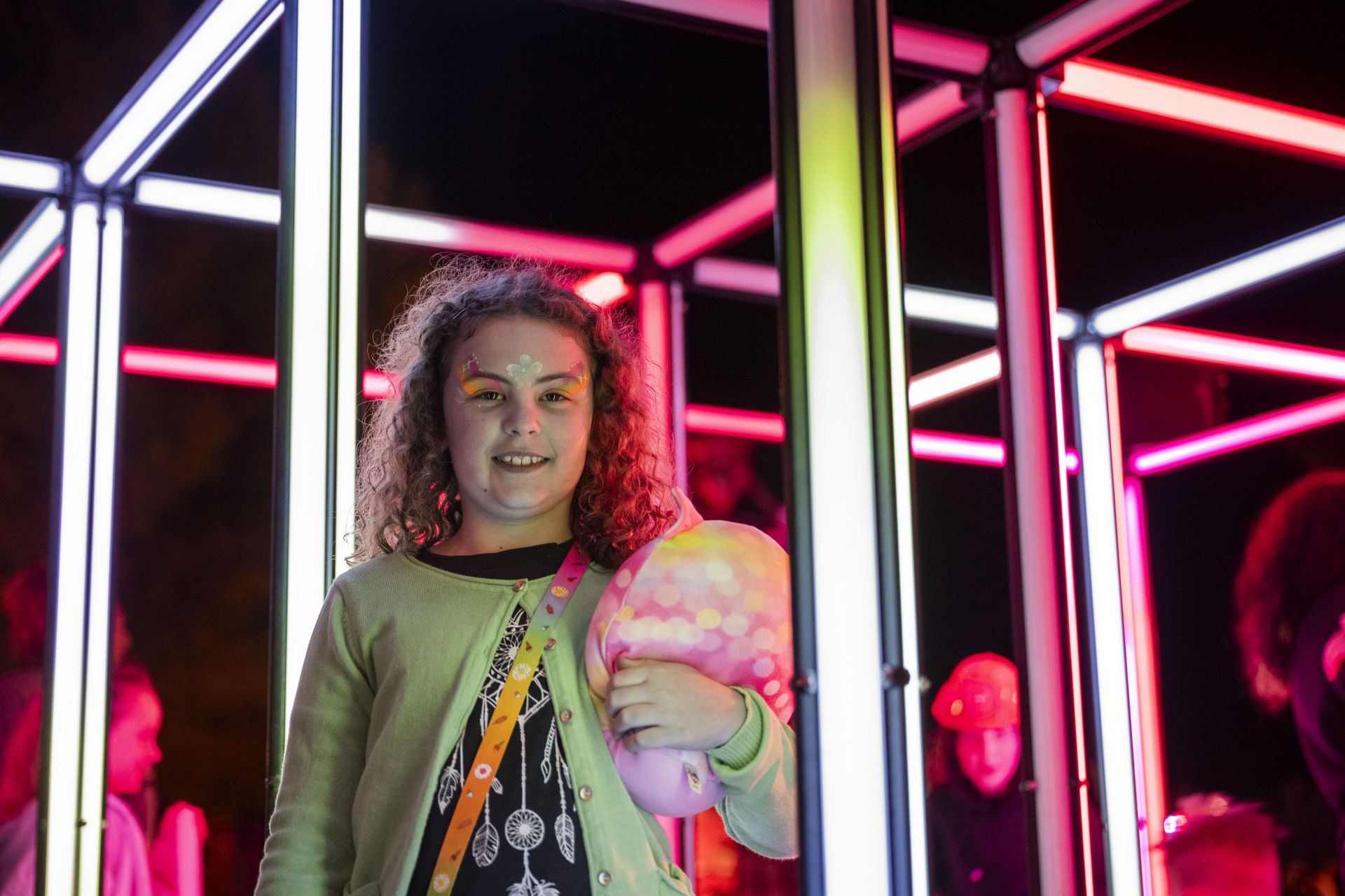 young girl smiling in front of art installation