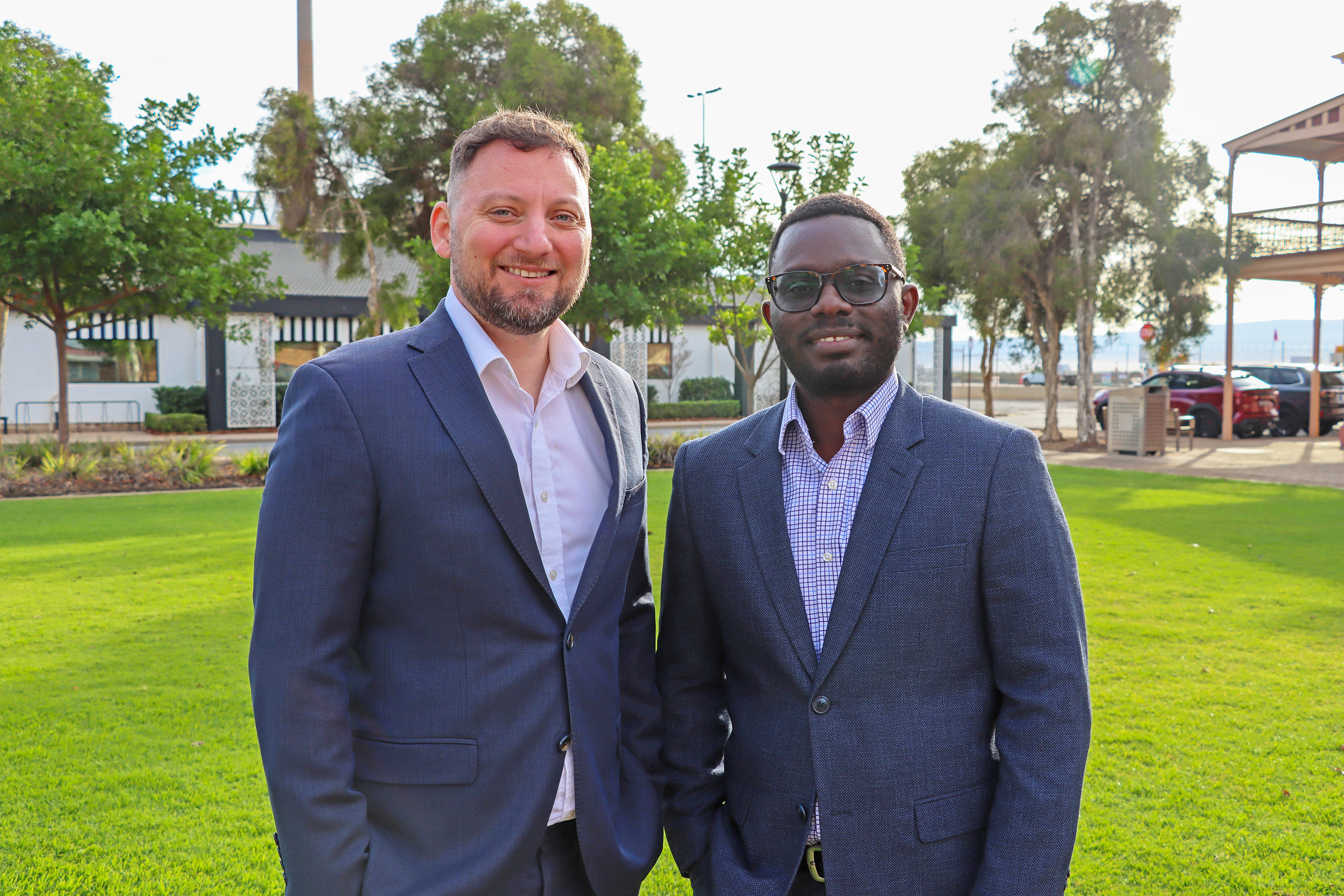 two new directors photographed at city park with green grass and gardens in background