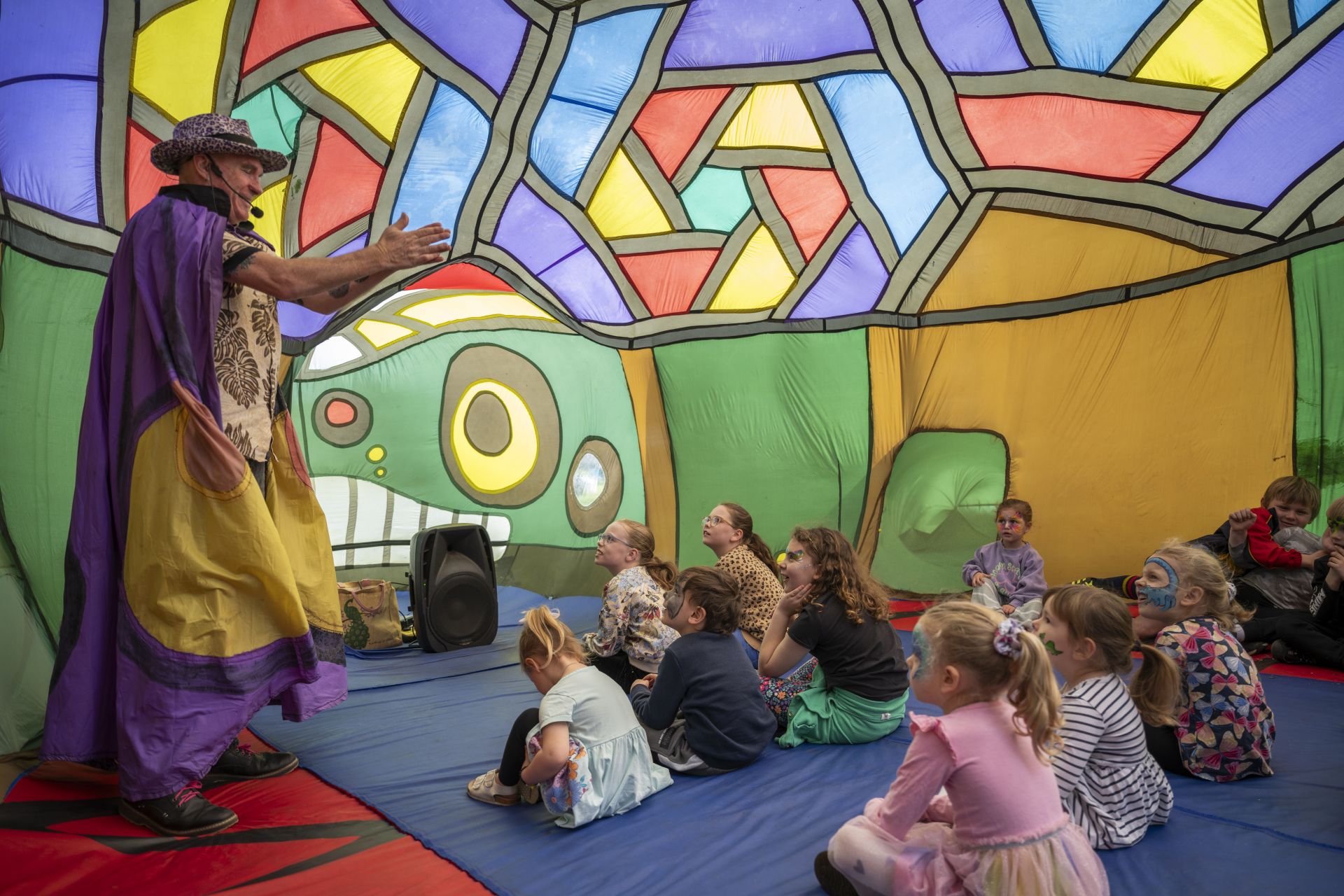 performer and children inside a colourful large nylon inflatable animal