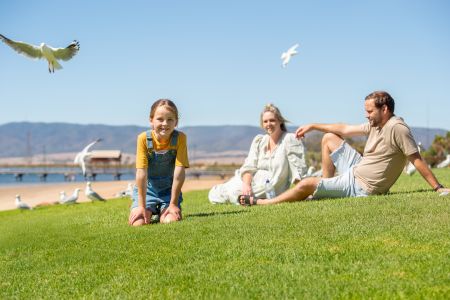 family sitting on grass at Solomontown Beach